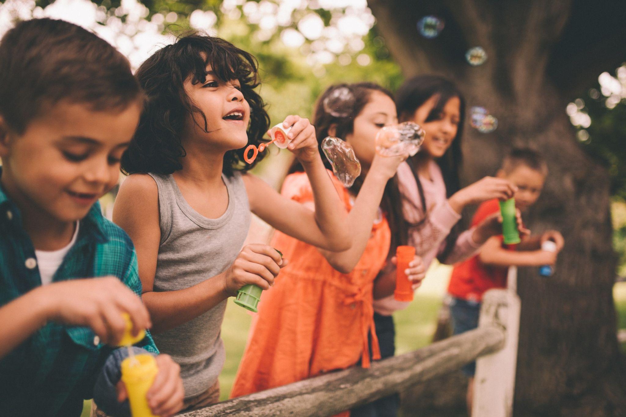 School aged children blowing bubbles